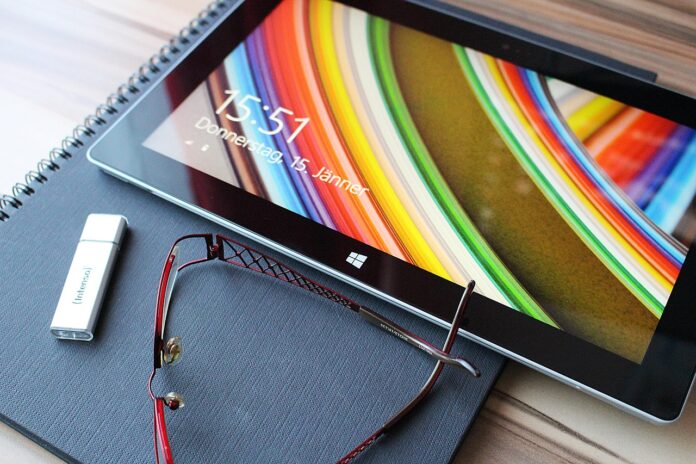 Clé USB posée à côté d'une tablette sous Windows