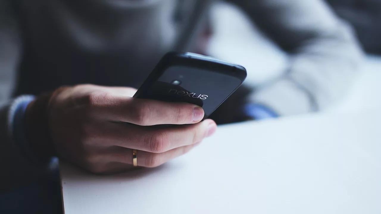 Main tenant un smartphone Android, illustration de la faille SMS de la mort